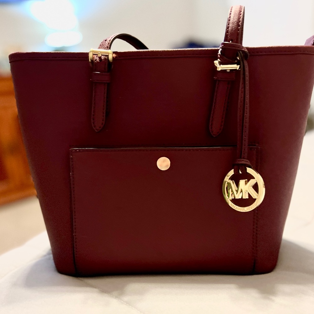 Michael Kors plum color purse. Never been used. Has several pockets.